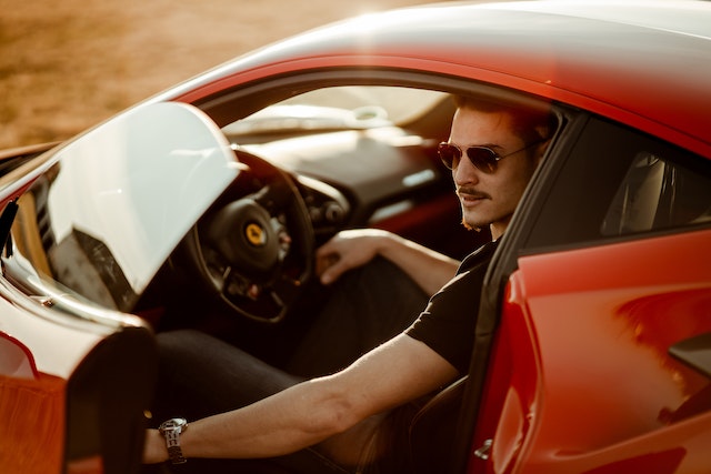 fine-looking-man-in-black-shirt-sitting-in-a-red-car