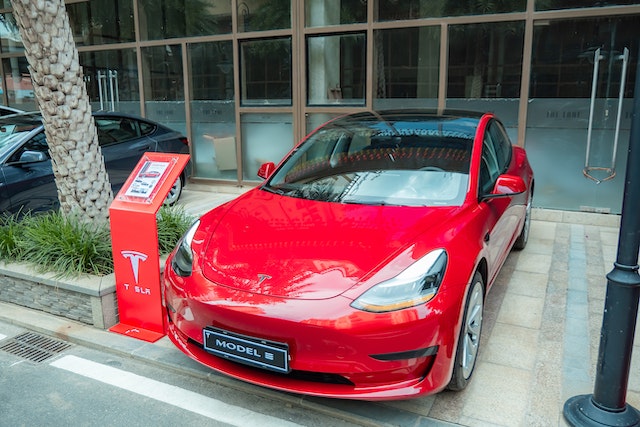 red-tesla-car-parked-outside-a-building