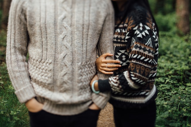 woman in black and white sweater hugging man in gray sweater